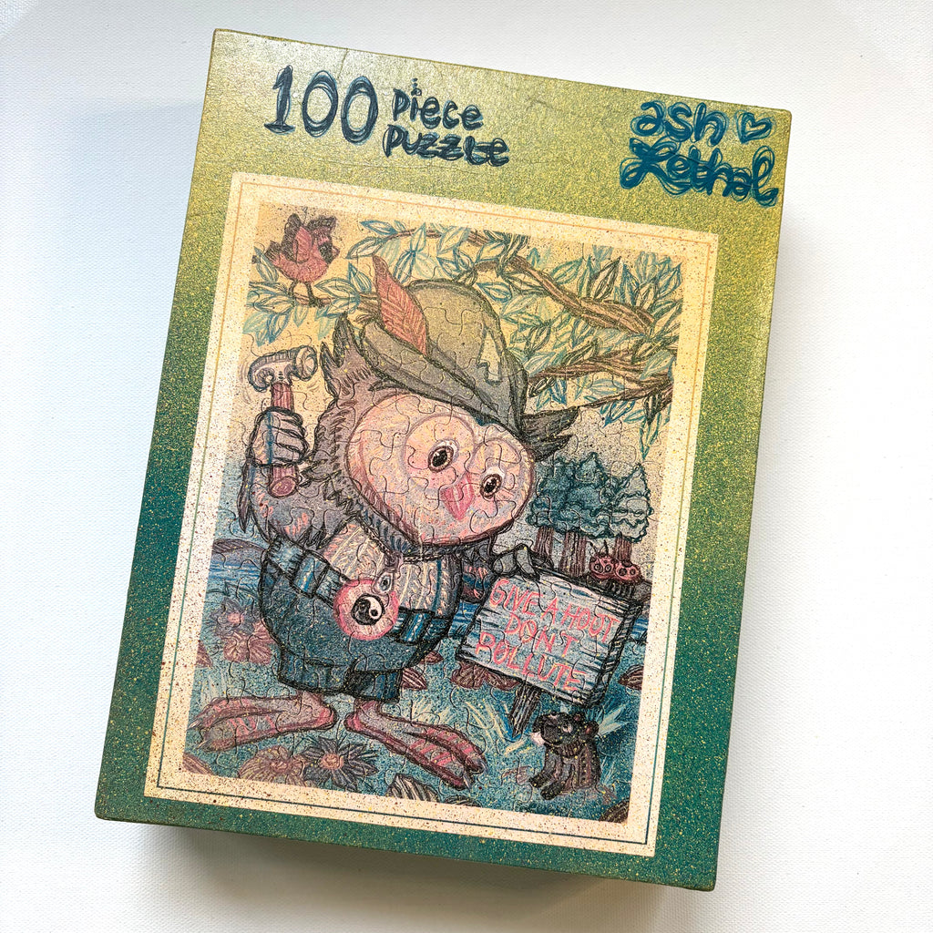 Jigsaw puzzle box with a cartoon owl character and 'ash lethal' branding on a white background