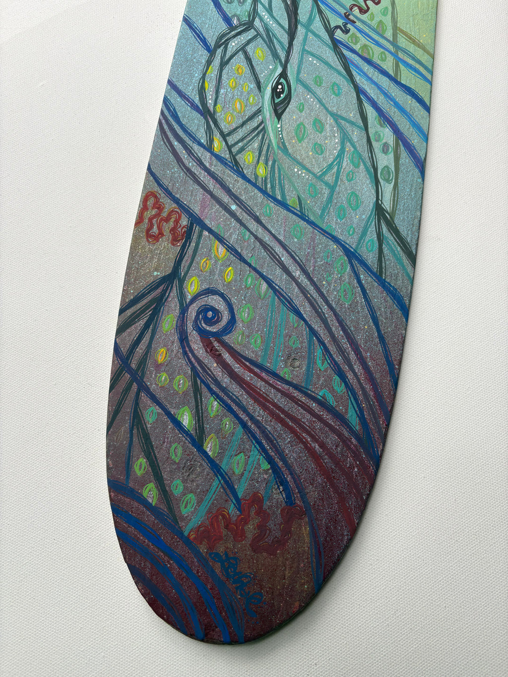 Decorative painted skateboard wood deck with artistic dolphins ocean design on a white background