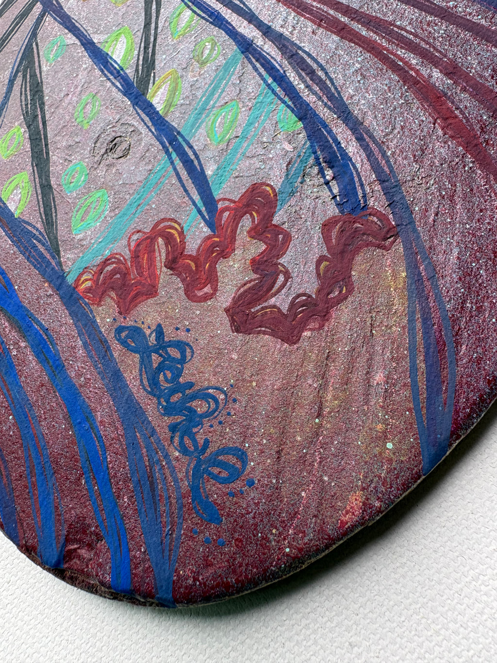 Decorative glass piece with floral design and 'Lethal' inscription on a textured white background