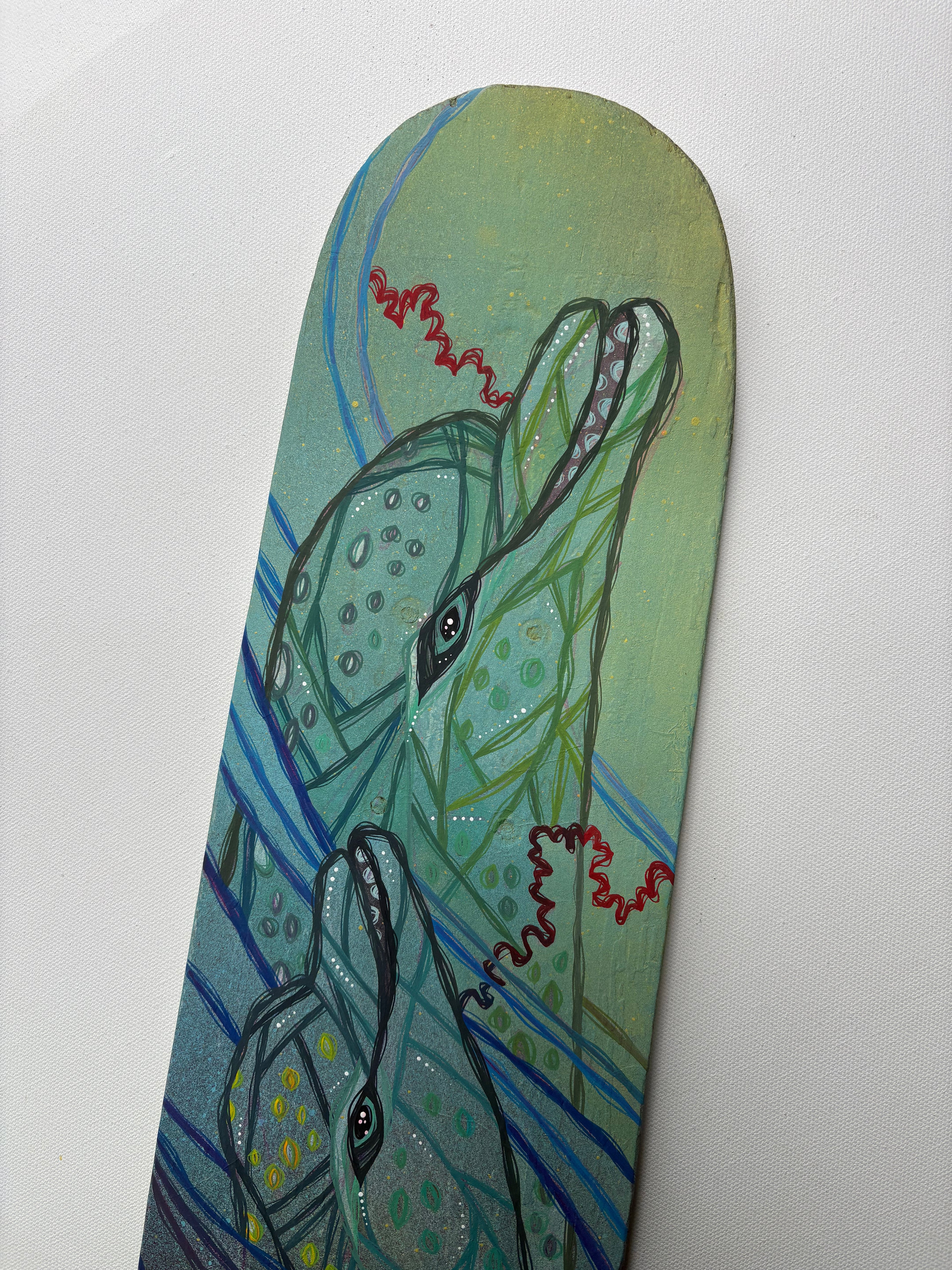 Skateboard deck with a colorful dolphins design on a white background