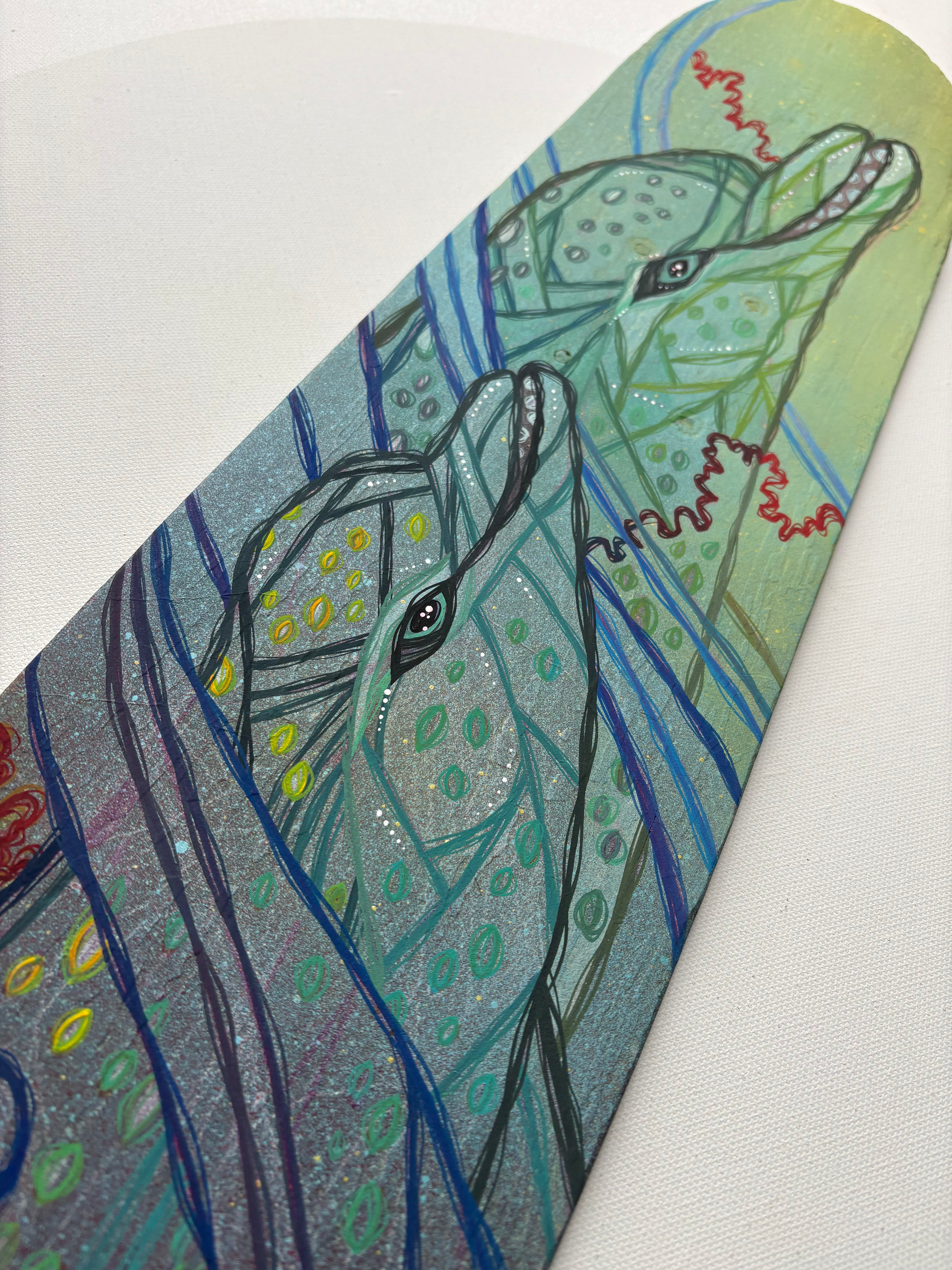 Colorful abstract design with two dolphins on a textured surface skateboard wood