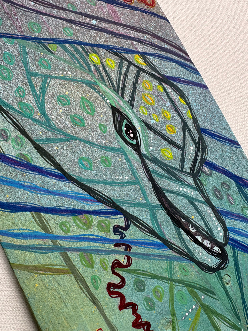 Close-up of a stylized dolphin head with intricate patterns on a textured background