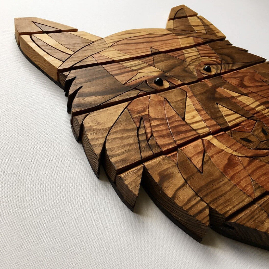 Wooden puzzle in the shape of a wolf's head on a white background
