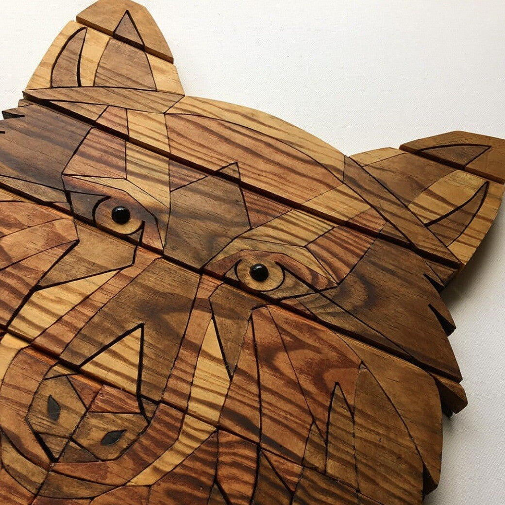 Wooden sculpture of a wolf's head on a white background