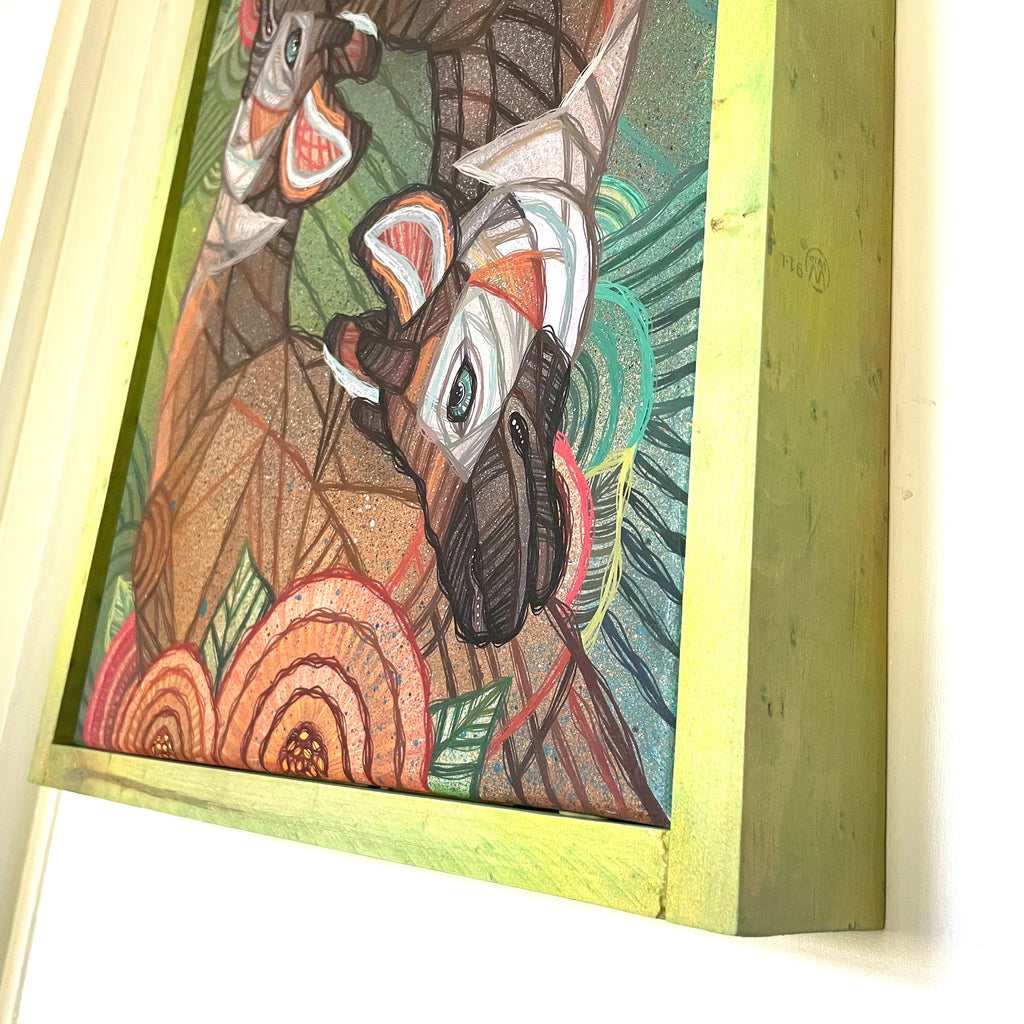 Colorful abstract artwork with a wooden frame on a white gallery wall