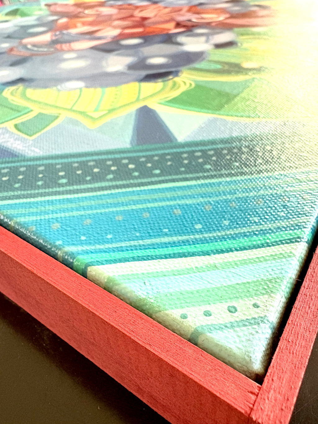 Close-up of a colorful canvas painting with geometric patterns and a red custom frame fine art 