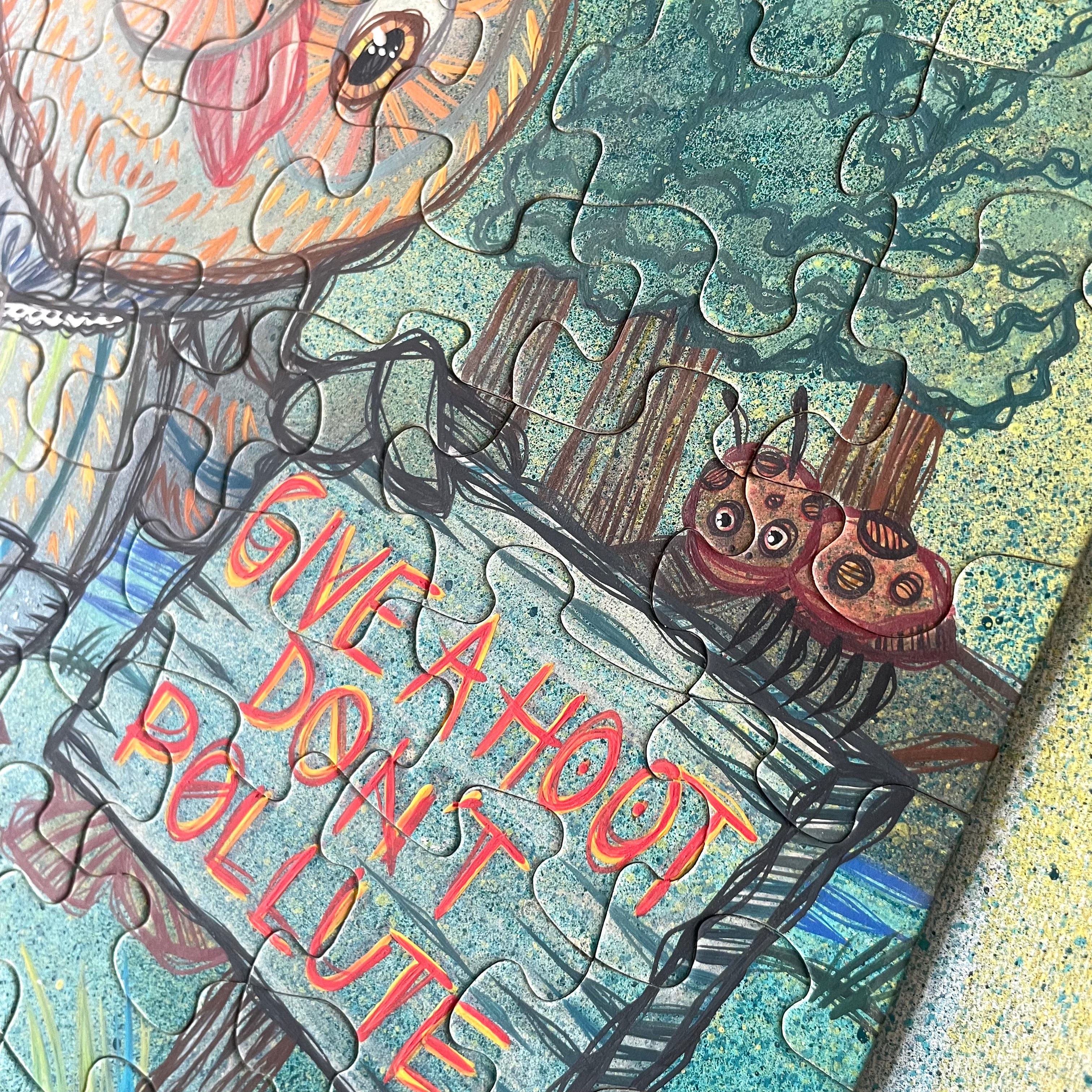Jigsaw puzzle with a cartoon design of owls and text 'Give a hoot, don't pollute' on a textured background.