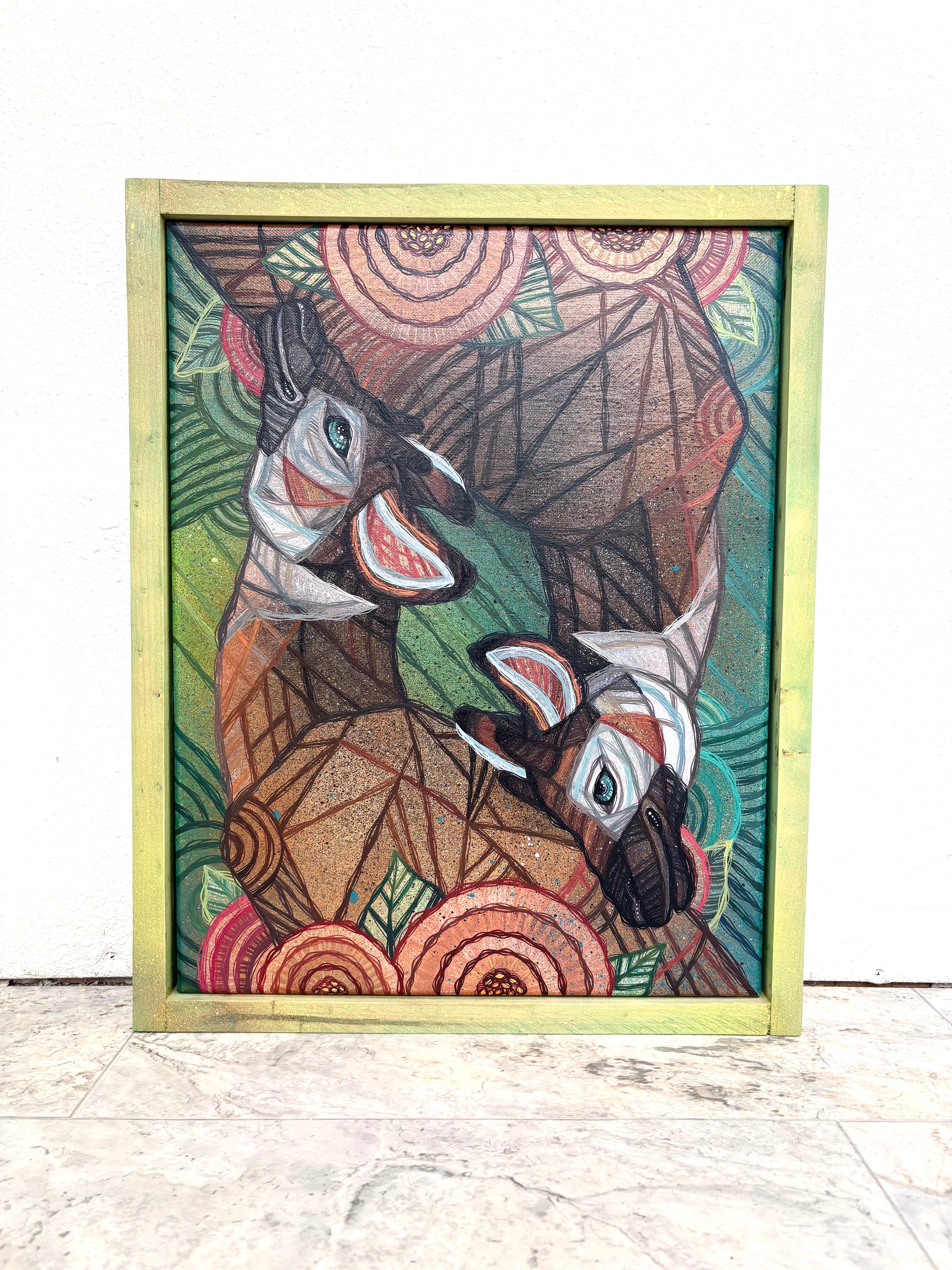 Framed artwork of two okapi deer with geometric patterns on a white gallery background