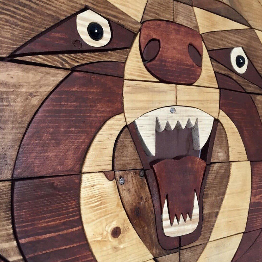 Wooden wall art of a bear's face with a geometric pattern.