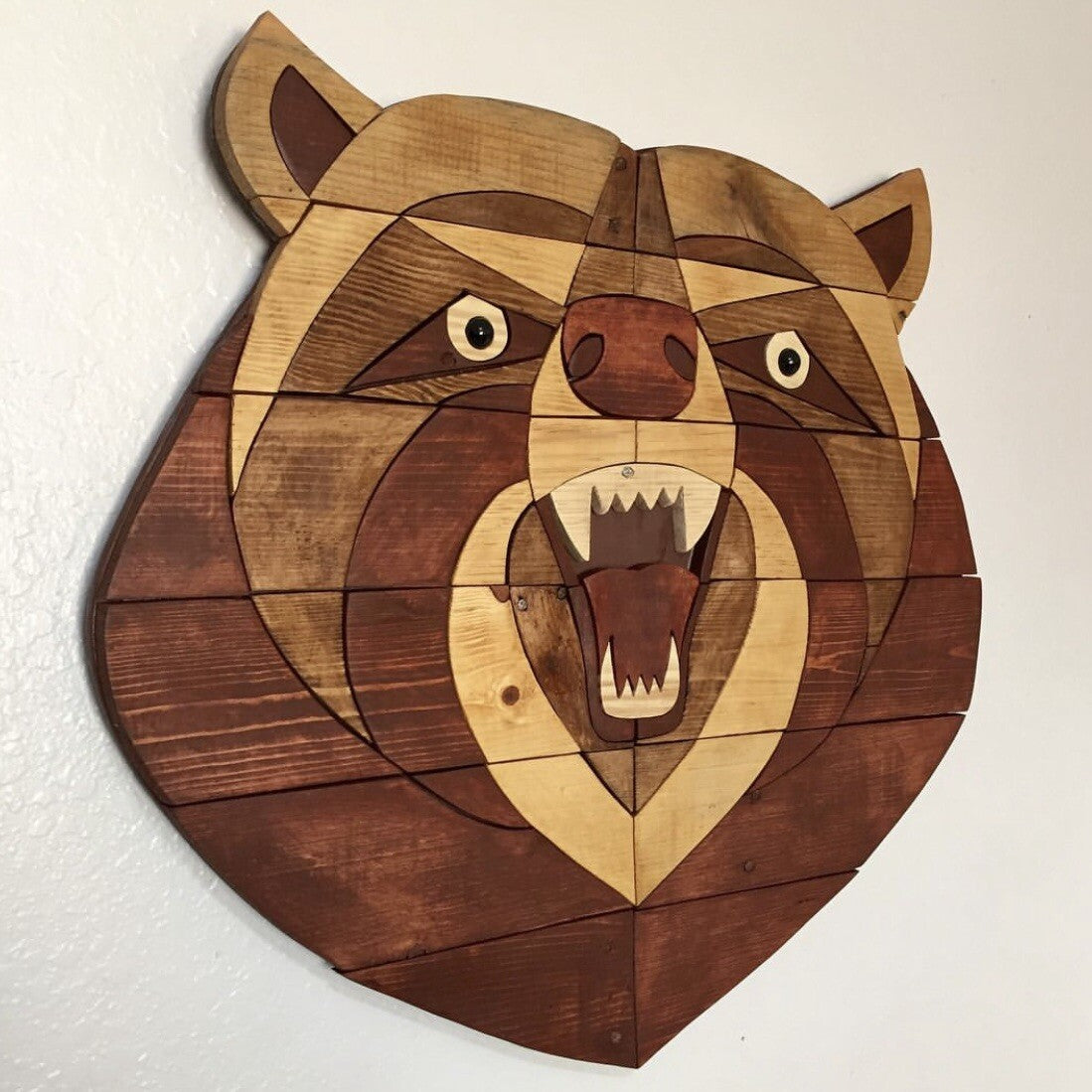 Wooden wall art of a bear head on a white background