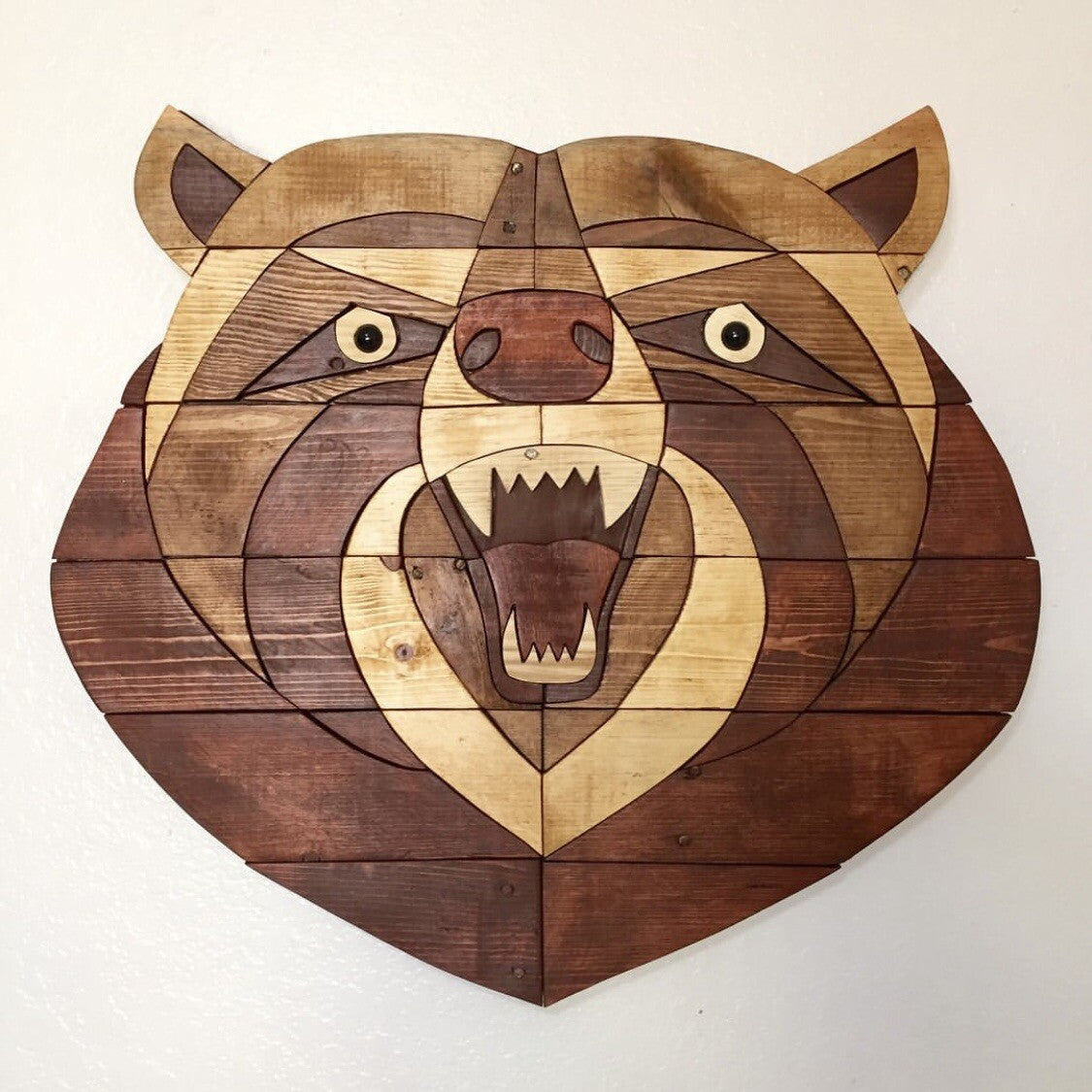Wooden art grizzly bear head wall art on a white gallery wall background